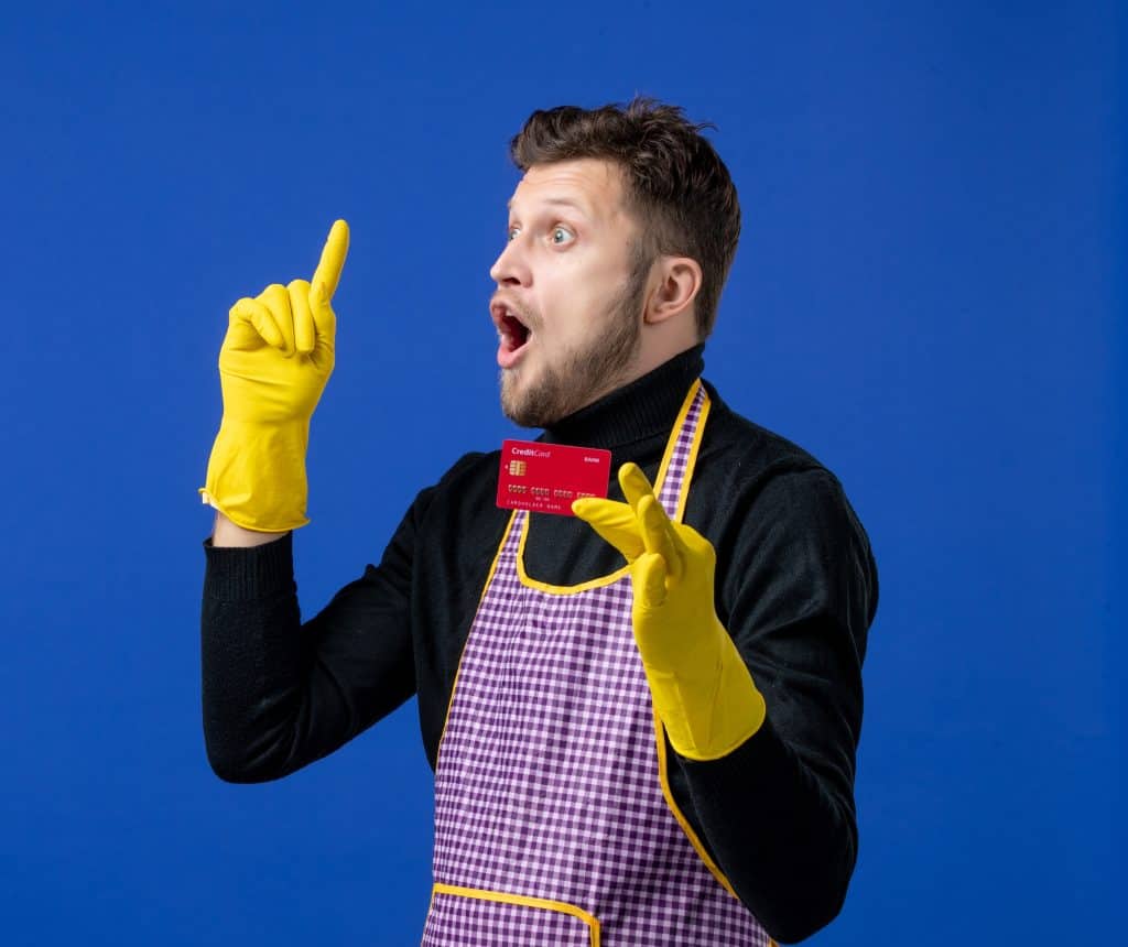 Clendo employee in yellow gloves is holding a dummy credit card signifying fixed upfront pricing