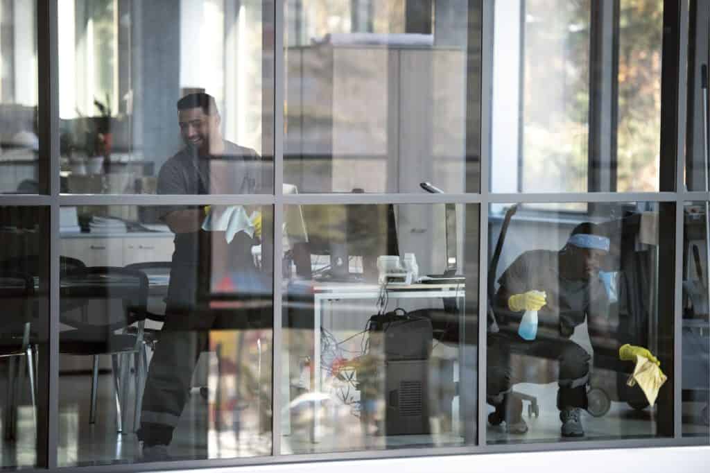 Two clendo cleaners cleaning windowsill in a commercial building. Clendo cleaners are doing detailed cleaning for the client.