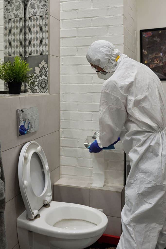 Clendo cleaner scrubbing bathroom tiles during a bond clean in Weston Creek